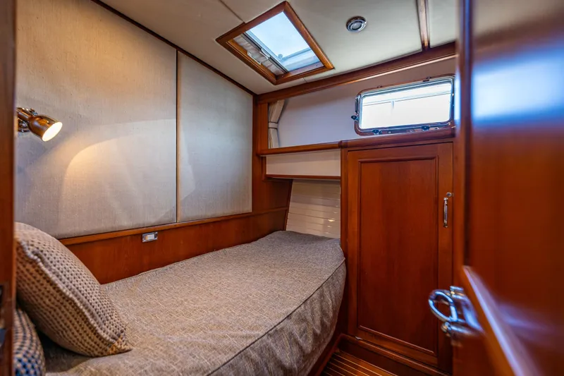 Slide: The Image of Cozy cabin interior of 2006 Grand Banks 47 Europa yacht with wooden finishes and single bed. - 16