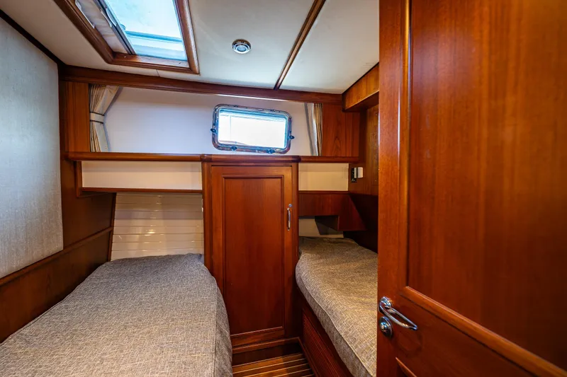 Slide: The Image of Cozy cabin interior of 2006 Grand Banks 47 Europa yacht with twin beds and wooden finish. - 17