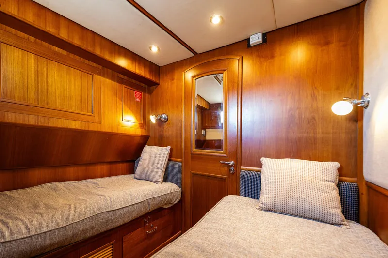 Slide: The Image of Interior cabin of 2006 Grand Banks 47 Europa yacht with twin beds and wooden paneling. - 18