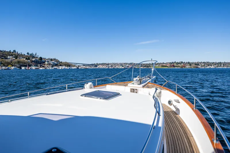 Slide: The Image of 2006 Grand Banks 47 Europa yacht cruising on a scenic blue lake under clear skies. - 22
