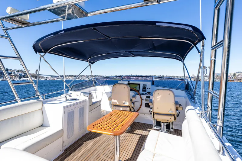 Slide: The Image of Flybridge of 2006 Grand Banks 47 Europa yacht with seating and helm, under blue canopy. - 27