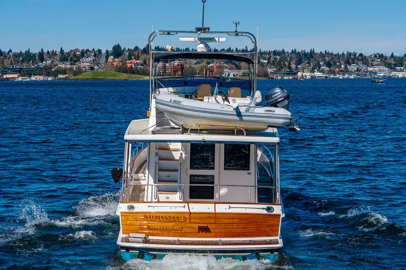 Slide: The Image of 2006 Grand Banks 47 Europa yacht cruising on a scenic lake with city skyline backdrop. - 3
