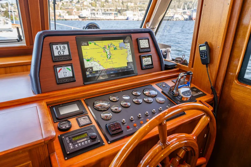 Slide: The Image of Helm of 2006 Grand Banks 47 Europa yacht with navigation instruments and wooden steering wheel. - 38