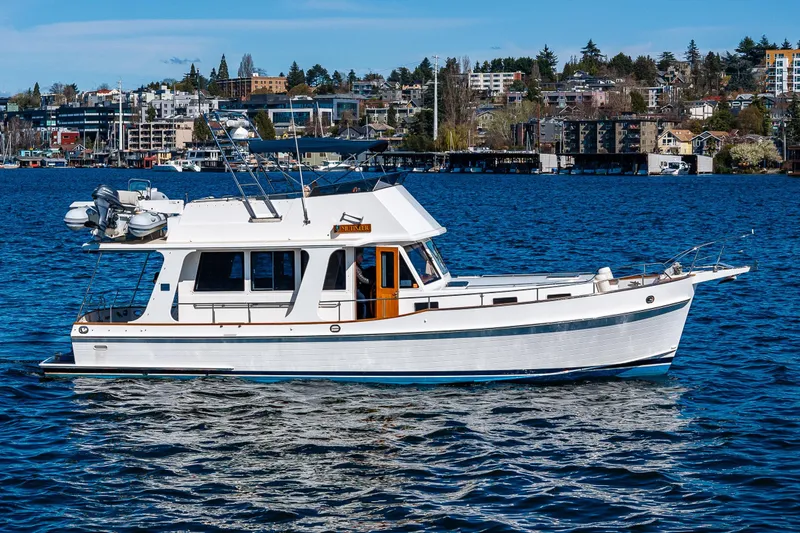 Slide: The Image of 2006 Grand Banks 47 Europa yacht on a scenic waterfront with urban backdrop. - 4