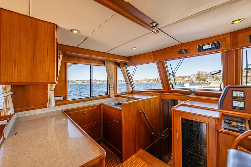 Slide: The Image of Interior of 2006 Grand Banks 47 Europa yacht, featuring wood cabinetry and panoramic windows. - 43