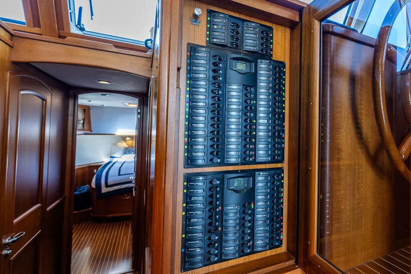 Slide: The Image of Electrical panel inside 2006 Grand Banks 47 Europa yacht, showcasing cabin interior and wood finish. - 44