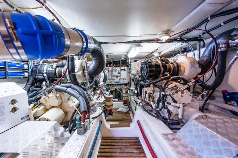 Slide: The Image of Engine room of a 2006 Grand Banks 47 Europa yacht, showcasing complex machinery and piping. - 52