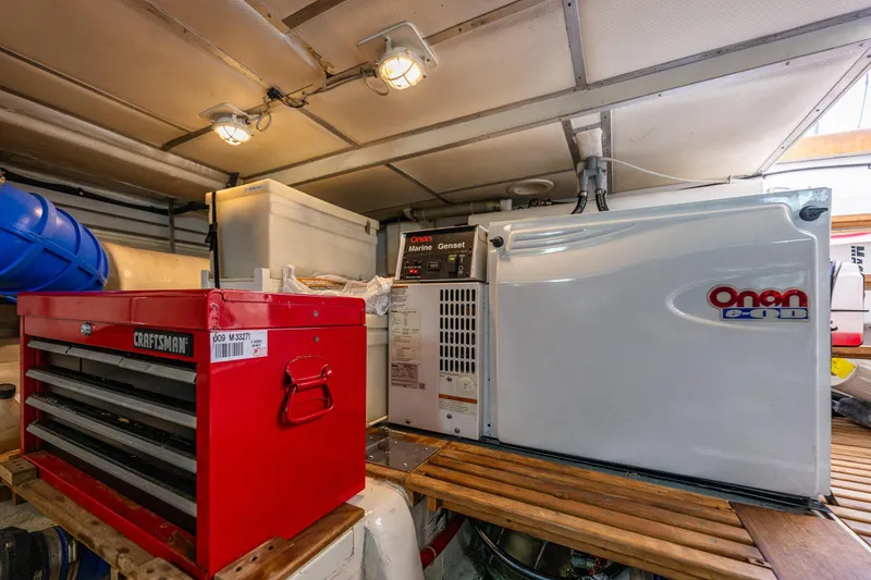 Slide: The Image of Engine room of 2006 Grand Banks 47 Europa with Onan generator and Craftsman toolbox. - 54