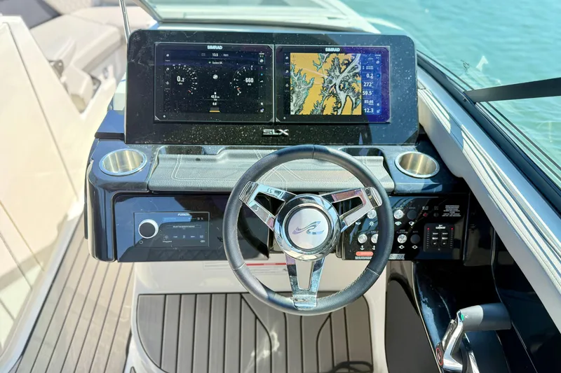 Slide: The Image of 2025 Sea Ray SLX 280 helm with dual Simrad displays and sleek steering wheel. - 15