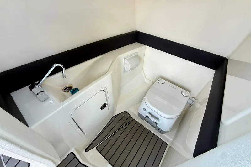 Slide: The Image of 2025 Sea Ray SLX 280 boat bathroom with sink and portable toilet. - 20