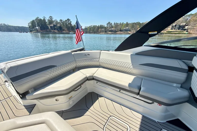 Slide: The Image of 2025 Sea Ray SLX 280 boat interior with luxurious seating and American flag on a serene lake. - 27
