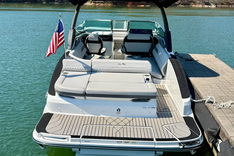 Slide: The Image of 2025 Sea Ray SLX 280 boat docked, featuring spacious seating and American flag. - 3