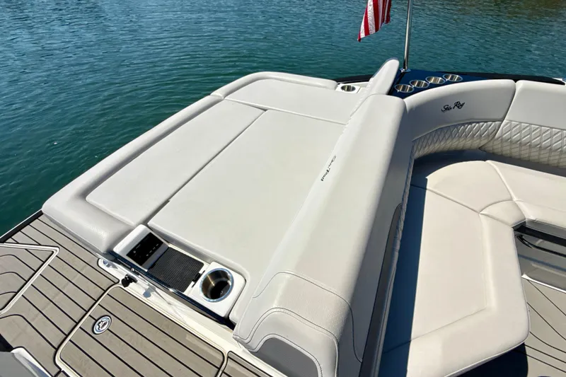 Slide: The Image of 2025 Sea Ray SLX 280 boat interior with luxurious seating and cup holders on a sunny day. - 32