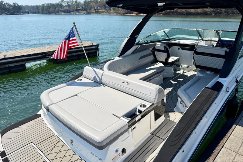 Slide: The Image of 2025 Sea Ray SLX 280 boat with spacious seating, docked by a serene lake. - 8