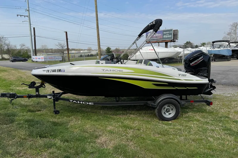 The Image of 2023 Tahoe T16 boat on trailer with Mercury engine, parked on grass. - 0