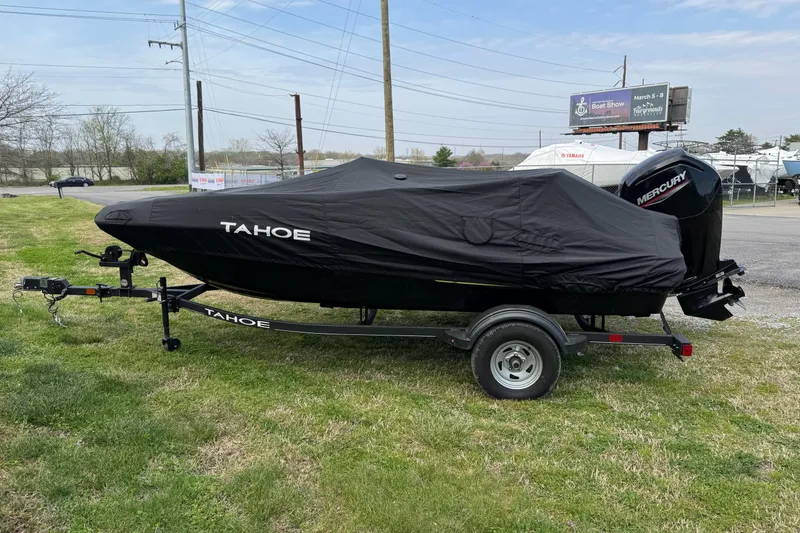 Slide: The Image of 2023 Tahoe T16 boat covered on trailer with Mercury engine, parked outdoors. - 2
