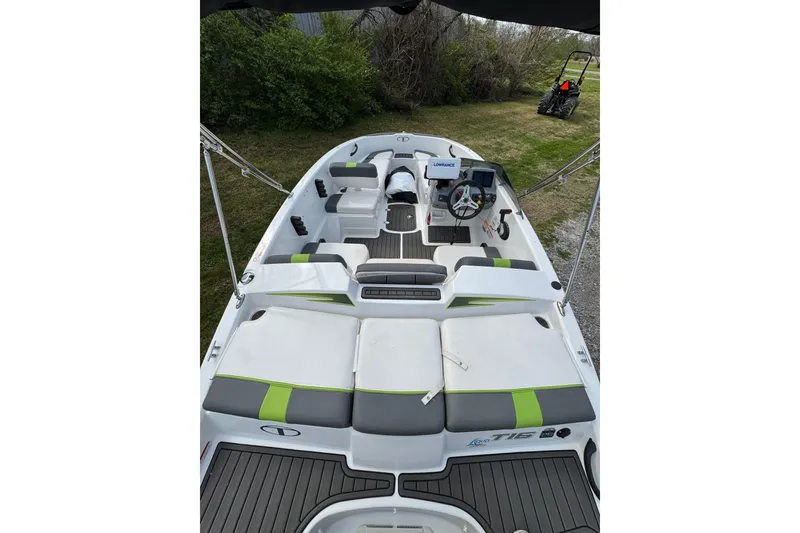 Slide: The Image of 2023 Tahoe T16 boat interior with seating and steering wheel, parked on grass. - 3