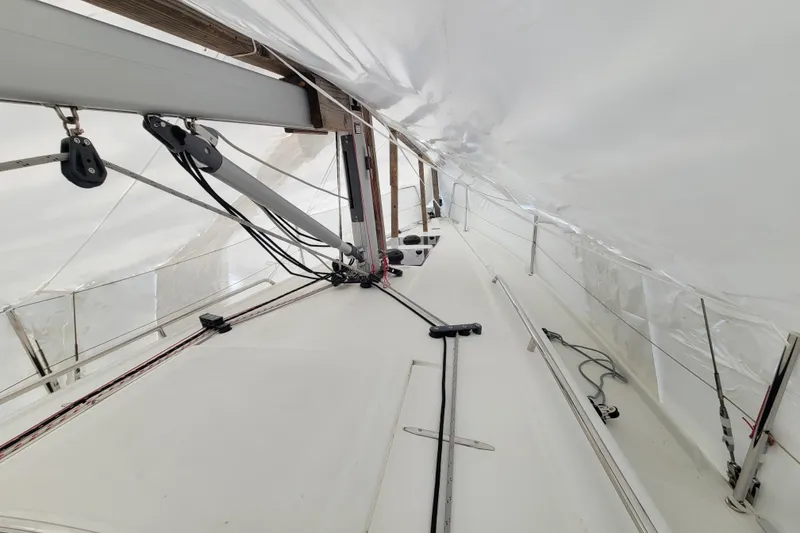 Slide: The Image of Beneteau Oceanis 30.1 sailboat deck under protective cover, showcasing rigging and fittings. - 21