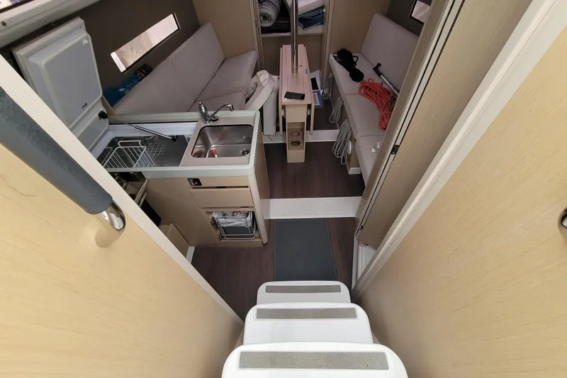 Slide: The Image of Interior of 2020 Beneteau Oceanis 30.1 yacht, featuring compact kitchen and seating area. - 25