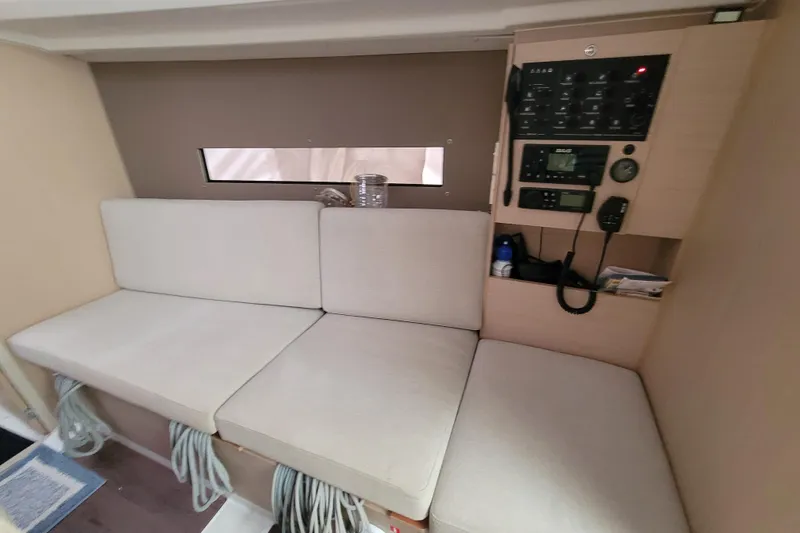Slide: The Image of Interior of 2020 Beneteau Oceanis 30.1 yacht with cushioned seating and control panel. - 30