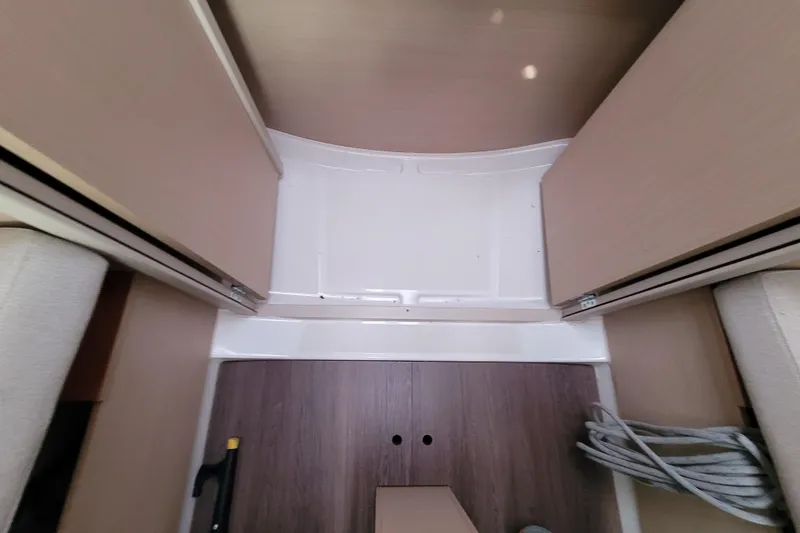Slide: The Image of Interior view of 2020 Beneteau Oceanis 30.1 sailboat, featuring wooden flooring and storage space. - 38