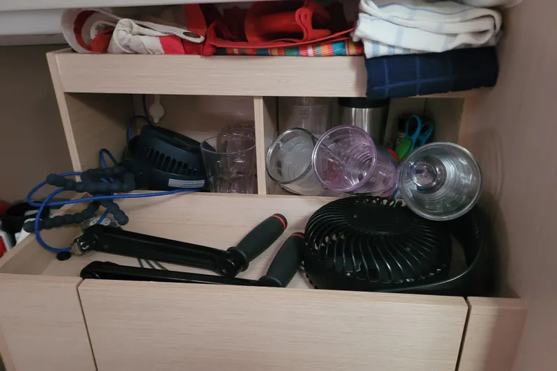 Slide: The Image of Storage shelf on a 2020 Beneteau Oceanis 30.1 yacht with various items. - 44