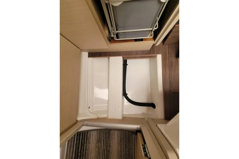Slide: The Image of Interior view of 2020 Beneteau Oceanis 30.1 sailboat, featuring storage compartment and flooring. - 54