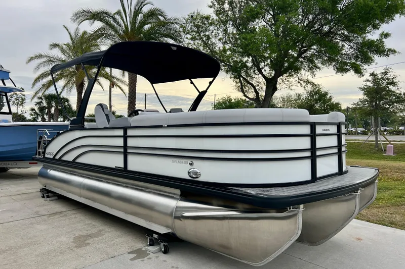 The Image of 2025 Harris Sunliner 230 pontoon boat parked outdoors. - 1