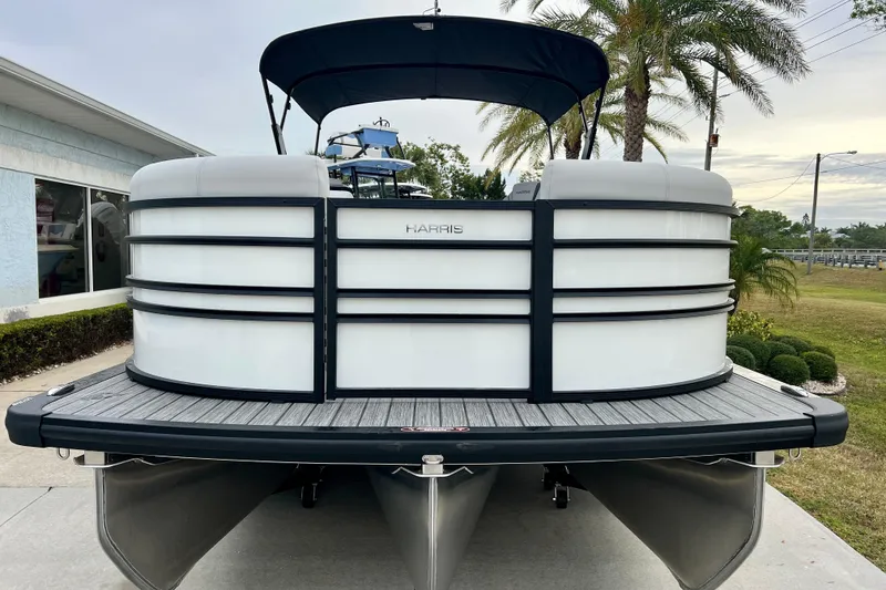 Slide: The Image of Harris Sunliner 230 pontoon boat 2025, parked on a concrete driveway. - 2