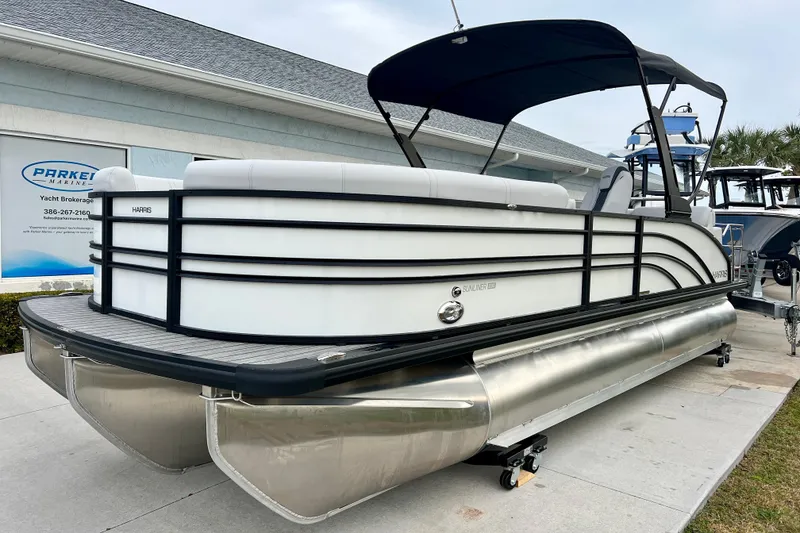 Slide: The Image of 2025 Harris Sunliner 230 pontoon boat parked outdoors. - 3