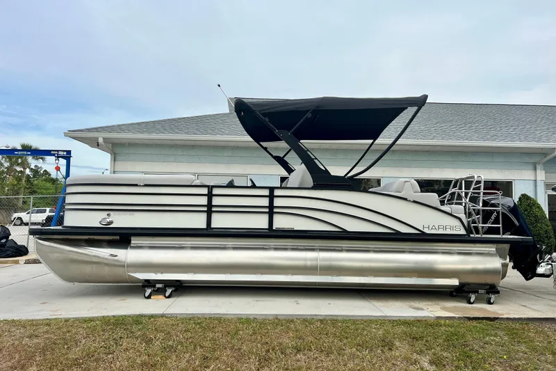 Slide: The Image of 2025 Harris Sunliner 230 pontoon boat parked outside a building. - 4