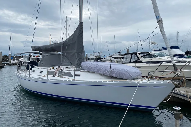 The Image of Cockpit view of a 1988 Hylas 42 sailboat on a serene lake with lush hills. - 0