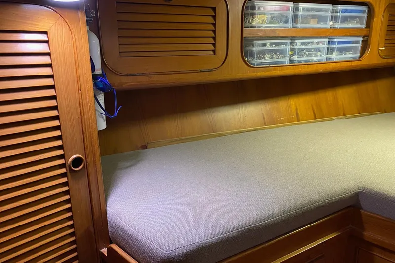 Slide: The Image of Cozy cabin interior of a 1988 Hylas 42 sailboat with wooden cabinetry and bedding. - 14