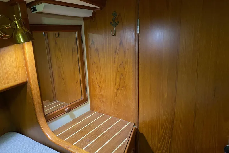 Slide: The Image of Cozy cabin interior of a 1988 Hylas 42 sailboat with wooden finishes and bedding. - 17