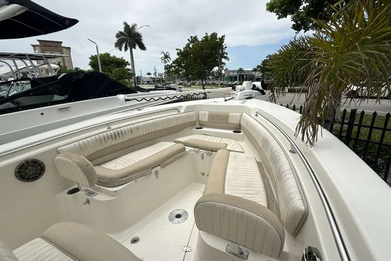 Slide: The Image of 2017 Sea Chaser 24 HFC boat interior with beige seating and palm trees in the background. - 14