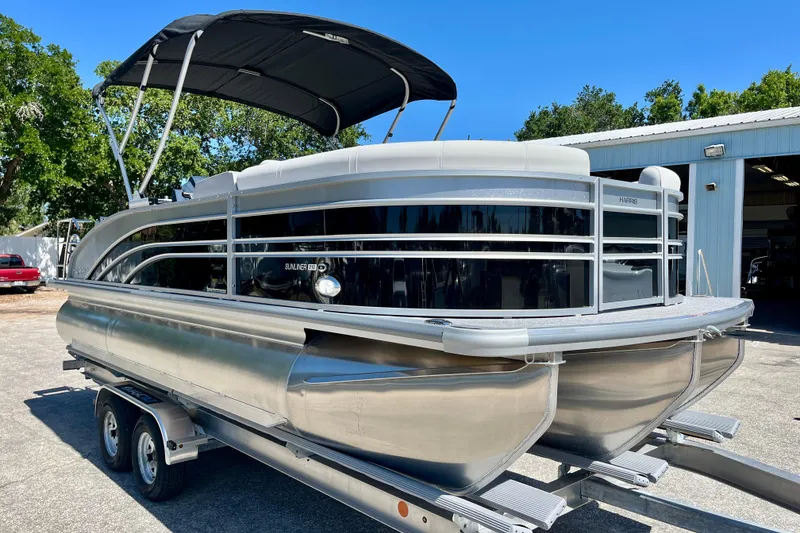 Slide: The Image of 2025 Harris Sunliner 210 pontoon boat on trailer, side view. - 6