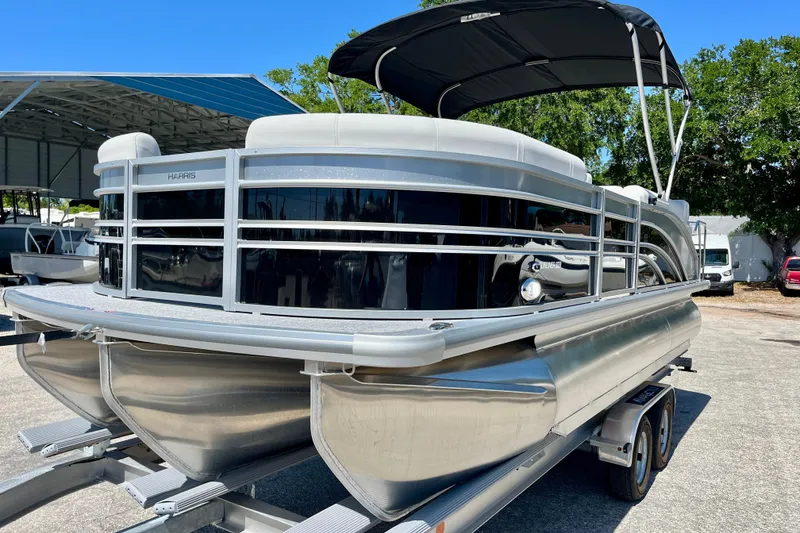 Slide: The Image of 2025 Harris Sunliner 210 pontoon boat on trailer, sunny day. - 8