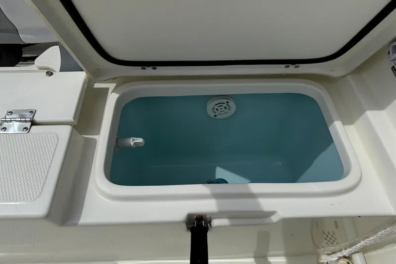 Slide: The Image of Livewell compartment on 2024 Mako 214 Center Console boat, open lid view. - 10