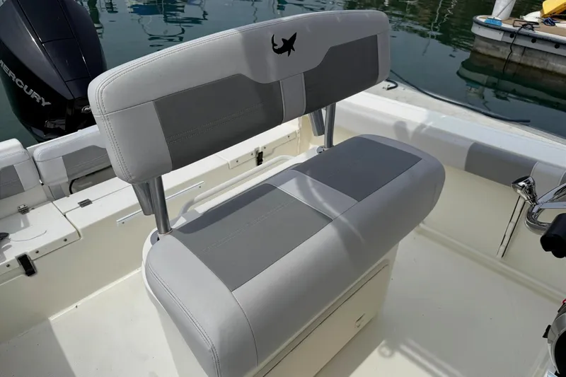 Slide: The Image of 2024 Mako 214 Center Console boat interior with cushioned seating and Mercury engine. - 13