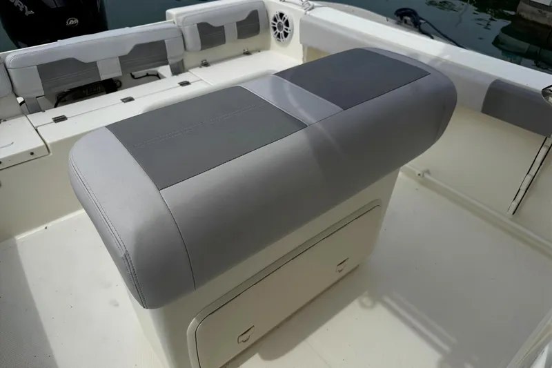 Slide: The Image of 2024 Mako 214 Center Console boat interior with cushioned seating and storage. - 14