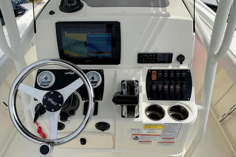 Slide: The Image of 2024 Mako 214 Center Console boat dashboard with steering wheel and navigation controls. - 18