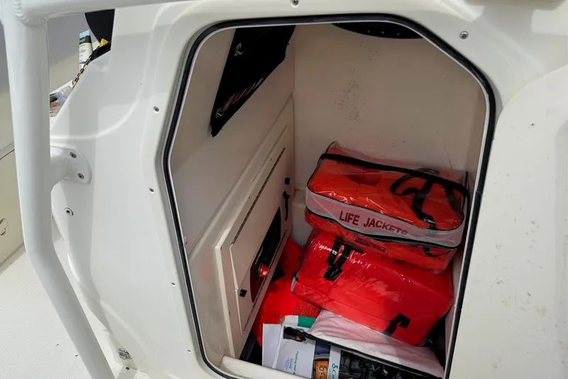 Slide: The Image of Storage compartment in a 2024 Mako 214 Center Console boat with life jackets. - 19