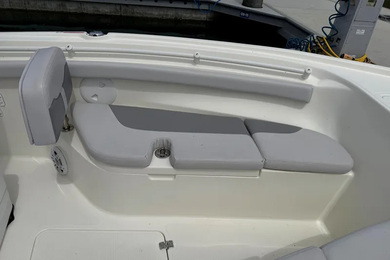 Slide: The Image of 2024 Mako 214 Center Console boat interior with cushioned seating and storage. - 21