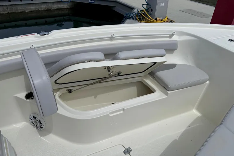 Slide: The Image of 2024 Mako 214 Center Console boat with open storage compartment and cushioned seating. - 22