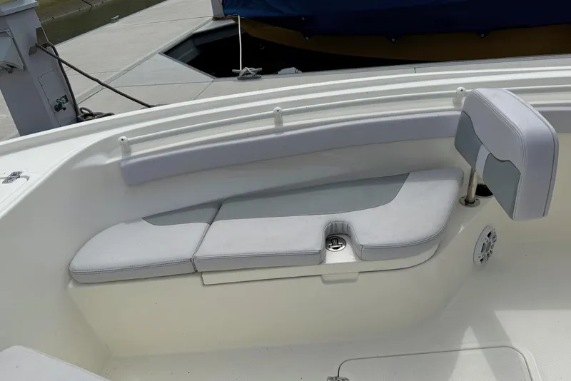 Slide: The Image of 2024 Mako 214 Center Console boat interior with cushioned seating and cup holder. - 24