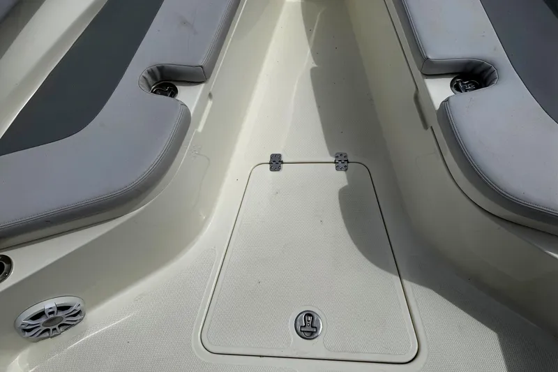 Slide: The Image of 2024 Mako 214 Center Console boat interior with cushioned seating and storage hatch. - 26