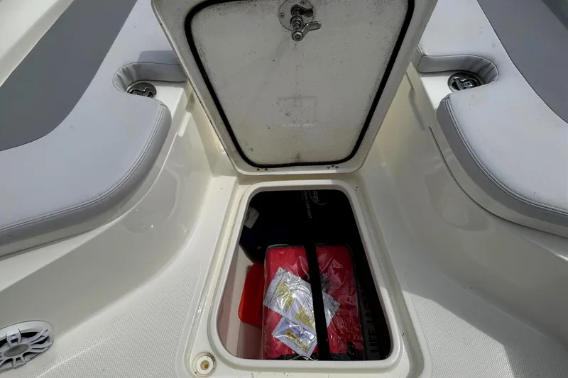 Slide: The Image of Open storage compartment on 2024 Mako 214 Center Console boat, showing interior contents. - 27