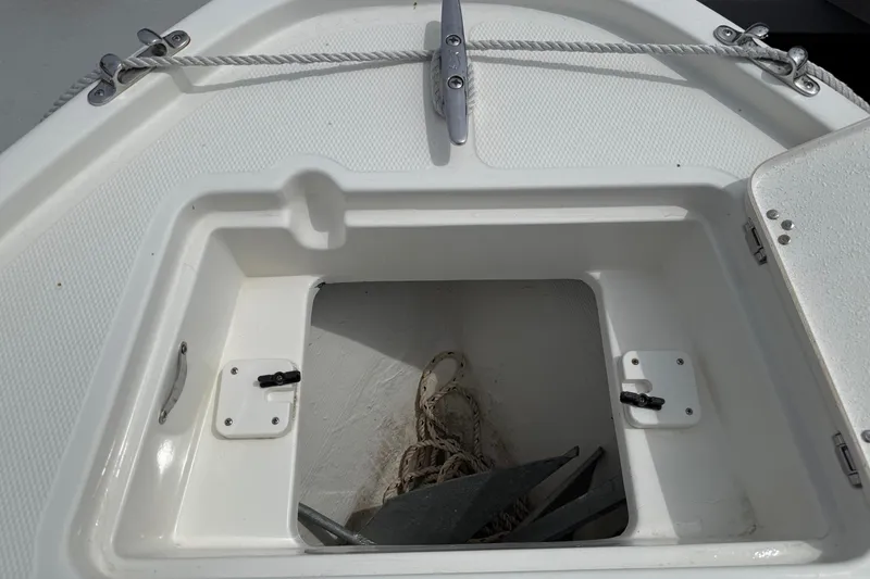 Slide: The Image of Anchor storage compartment on 2024 Mako 214 Center Console boat, featuring rope and anchor. - 28