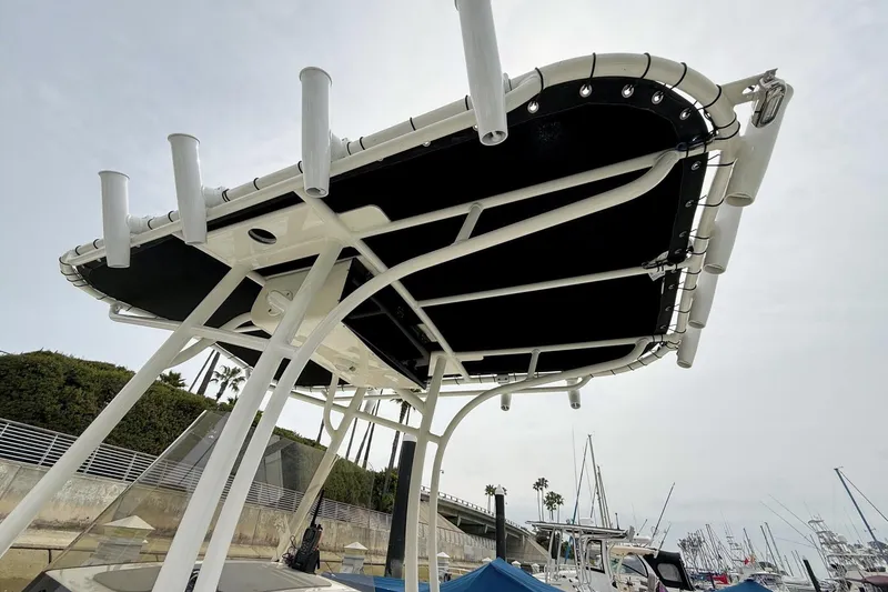 Slide: The Image of 2024 Mako 214 Center Console boat with T-top and rod holders at marina. - 29