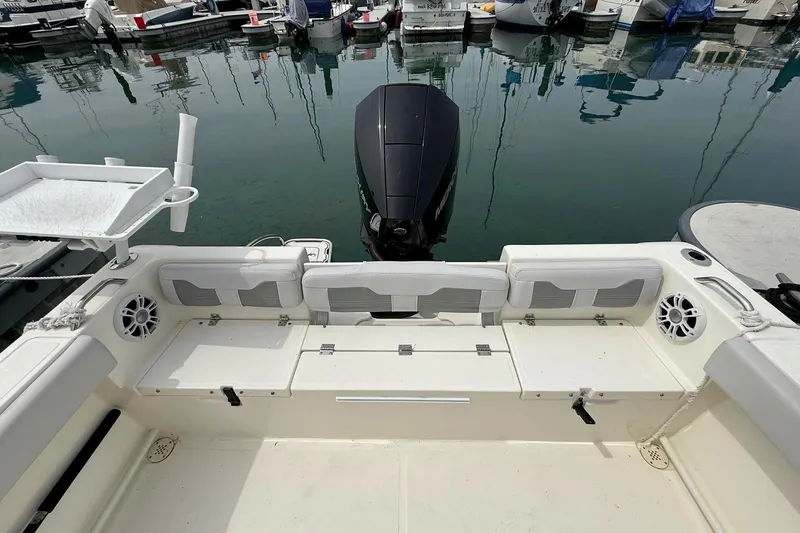 Slide: The Image of 2024 Mako 214 Center Console boat interior with seating and motor at marina. - 8
